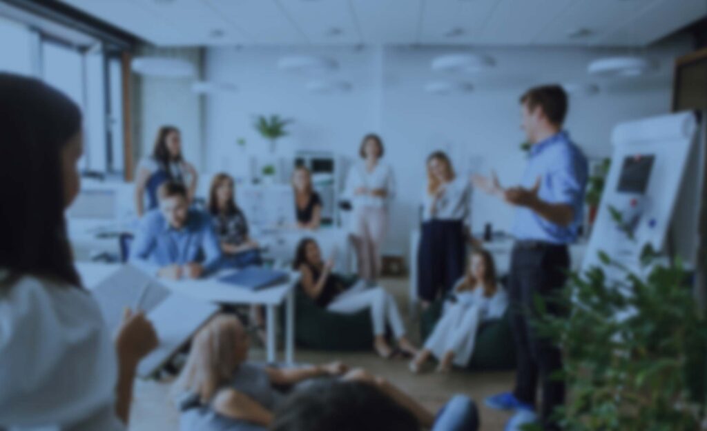 Verschwommene Aufnahme eines Teams bei Präsentation im modernen Büro